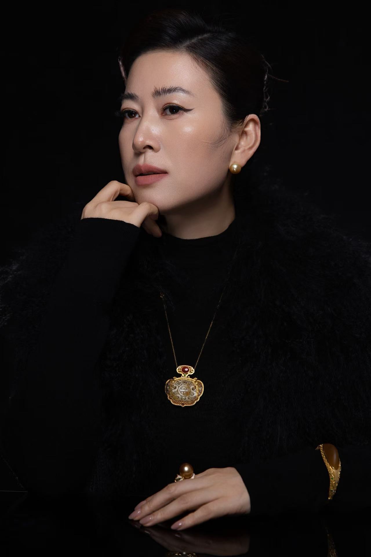 Meili Lu, founder of M&T Jewelry, wearing pearl earrings and a pendant